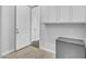 Hallway with a practical gray filing cabinet to provide organized storage and two access doors at 9942 E Rotation Dr, Mesa, AZ 85212