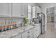 Bright kitchen features white cabinets, granite countertops, stainless steel appliances, and charming beverage station at 9942 E Rotation Dr, Mesa, AZ 85212