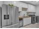Well-lit laundry room features gray stainless-steel appliances, white cabinets, and a utility sink at 9942 E Rotation Dr, Mesa, AZ 85212