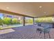 Spacious covered patio with brick pavers, outdoor seating, grill, and hot tub, perfect for outdoor entertaining at 9942 E Rotation Dr, Mesa, AZ 85212