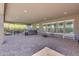 Wide-open covered patio featuring brick pavers, grill, hot tub, seating, and large windows at 9942 E Rotation Dr, Mesa, AZ 85212