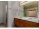Bathroom with double sinks and a large mirror above wood cabinets at 1101 S Hazel St, Gilbert, AZ 85296