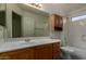 Bathroom features a single sink, vanity with wood cabinets, toilet, and tub with shower at 1101 S Hazel St, Gilbert, AZ 85296