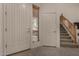 Bright entryway featuring tile flooring, a white front door, adjacent window with blinds and a staircase leading to the upper level at 1101 S Hazel St, Gilbert, AZ 85296
