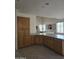 Open concept kitchen connects to a spacious living room featuring wooden cabinets and a breakfast bar at 1101 S Hazel St, Gilbert, AZ 85296