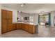 Modern kitchen with stainless steel appliances, ample counter space, wooden cabinets, and access to the living room area at 1101 S Hazel St, Gilbert, AZ 85296