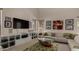 Bright living room with a white sofa, large TV, and modern shelving, illuminated by natural light from the windows at 1101 S Hazel St, Gilbert, AZ 85296