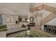 Open-concept living room with view of the kitchen, staircase to the upper level, a white sofa, and lots of natural light at 1101 S Hazel St, Gilbert, AZ 85296