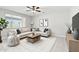 Bright living room with a large window, comfortable sectional sofa, ceiling fan, and stylish décor at 19054 W Becker Ln, Surprise, AZ 85388