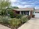 Charming single-story brick home featuring a beautifully landscaped front yard with colorful flowers and a decorative fence at 2921 E Cheery Lynn Rd, Phoenix, AZ 85016