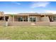 View of the house from the backyard showing a patio with sliding glass doors and an iron gate at 10014 E Michigan Ave, Sun Lakes, AZ 85248