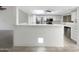 Open kitchen with modern appliances, white cabinetry and breakfast bar with tiled floors at 10014 E Michigan Ave, Sun Lakes, AZ 85248