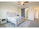 Bright bedroom with a decorative bedspread, wood accents, and a view into the ensuite bathroom at 10134 E Supernova Dr, Mesa, AZ 85212