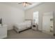 Bright bedroom with a neutral color scheme, featuring a white bed, dresser, and full length mirror at 10134 E Supernova Dr, Mesa, AZ 85212
