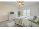 Bright bedroom featuring a ceiling fan, neutral color palette, and a window with plantation shutters at 10134 E Supernova Dr, Mesa, AZ 85212
