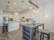Open-concept kitchen and dining area features modern lighting, white cabinets, and stainless steel appliances at 10134 E Supernova Dr, Mesa, AZ 85212