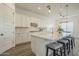 Bright kitchen with white cabinetry, subway tile backsplash, and an island with bar stool seating at 10134 E Supernova Dr, Mesa, AZ 85212