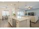 Open-concept kitchen with quartz counters, a farm sink, and bar stool seating overlooking the living area at 10134 E Supernova Dr, Mesa, AZ 85212