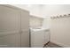 Clean laundry room with modern washer and dryer, storage cabinet and a shelf at 10134 E Supernova Dr, Mesa, AZ 85212