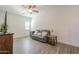 Living room features a comfortable couch, ceiling fan, and large window at 10134 E Supernova Dr, Mesa, AZ 85212