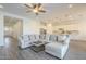 Inviting living room featuring stylish wood-look flooring, a comfortable sectional, and an open layout at 10134 E Supernova Dr, Mesa, AZ 85212