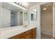 Bright bathroom featuring a large mirror, vanity with wood cabinets, and a separate shower area at 10444 N 69Th St # 224, Paradise Valley, AZ 85253