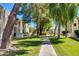 Walkway through beautifully landscaped grounds, showcasing lush lawns and mature trees between buildings at 10444 N 69Th St # 224, Paradise Valley, AZ 85253