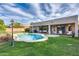 Large backyard with inground pool, covered patio, and lush green grass at 11502 E Rafael Ave, Mesa, AZ 85212