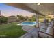 Covered patio overlooking a backyard featuring a sparkling pool with waterfall feature and lush greenery at 11502 E Rafael Ave, Mesa, AZ 85212