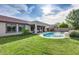 Private backyard oasis with a refreshing swimming pool, lush green lawn, and a covered patio at 11502 E Rafael Ave, Mesa, AZ 85212
