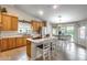Open kitchen and dining area with an island, wooden cabinets, stainless steel appliances, and backyard access at 11502 E Rafael Ave, Mesa, AZ 85212