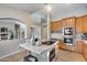 Bright kitchen with an island that includes seating and modern appliances with views to the living room at 11502 E Rafael Ave, Mesa, AZ 85212