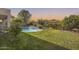 Expansive backyard showcasing lush greenery, a sparkling pool with a waterfall, and privacy fencing at 11502 E Rafael Ave, Mesa, AZ 85212