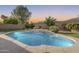 Inviting backyard pool features a serene waterfall, surrounding stone coping, and lush landscaping at 11502 E Rafael Ave, Mesa, AZ 85212
