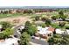 An aerial view showcases residences within a community adjacent to a lush golf course, framed by distant mountain views at 11837 N 40Th Pl, Phoenix, AZ 85028