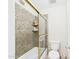 Tiled bathtub and shower area with glass doors and granite surround at 11837 N 40Th Pl, Phoenix, AZ 85028