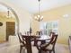 Cozy dining area with round table, chandelier, and plantation shutters, adjacent to a brightly lit living space at 11837 N 40Th Pl, Phoenix, AZ 85028