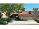Charming home featuring a red tile roof, arched windows, and a well-manicured lawn, nestled under a mature shade tree at 11837 N 40Th Pl, Phoenix, AZ 85028