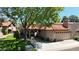 Charming home featuring a red tile roof, arched windows, and a well-manicured lawn, nestled under a mature shade tree at 11837 N 40Th Pl, Phoenix, AZ 85028