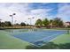 Outdoor tennis court with blue surface, surrounded by mature trees and landscaping at 11837 N 40Th Pl, Phoenix, AZ 85028