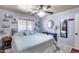 This is a comfortable bedroom featuring a ceiling fan, wood-look flooring, and decorative shelving at 12048 W Dahlia Dr, El Mirage, AZ 85335