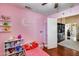 Pink bedroom showcasing decor, wood floors, and open access to other areas of the home at 12048 W Dahlia Dr, El Mirage, AZ 85335