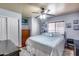 This is a bright bedroom featuring a ceiling fan, wood-look flooring, and a comfortable queen bed at 12048 W Dahlia Dr, El Mirage, AZ 85335