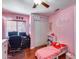 Pink bedroom featuring built-in closet, desk, and a cute toddler bed, perfect for a young  at 12048 W Dahlia Dr, El Mirage, AZ 85335