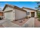 Inviting beige home featuring desert landscaping, a two-car garage, and a tile roof under a bright blue sky at 12048 W Dahlia Dr, El Mirage, AZ 85335