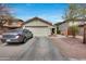 Inviting home featuring desert landscaping, two car garage, and long driveway, offering both beauty and convenience at 12048 W Dahlia Dr, El Mirage, AZ 85335