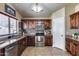 Cozy kitchen features stainless steel appliances, mosaic backsplash, and plentiful wooden cabinetry at 12048 W Dahlia Dr, El Mirage, AZ 85335