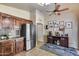 Kitchen featuring stainless steel refrigerator, ample wooden cabinetry, and adjacent eat-in area at 12048 W Dahlia Dr, El Mirage, AZ 85335