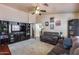 Cozy living room features dark wood floors, neutral walls, ceiling fan and built-in media center, ideal for relaxing at 12048 W Dahlia Dr, El Mirage, AZ 85335