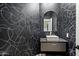 Stylish powder room featuring a black accent wall with modern design and a sleek vanity with vessel sink at 12055 E Clinton St, Scottsdale, AZ 85259